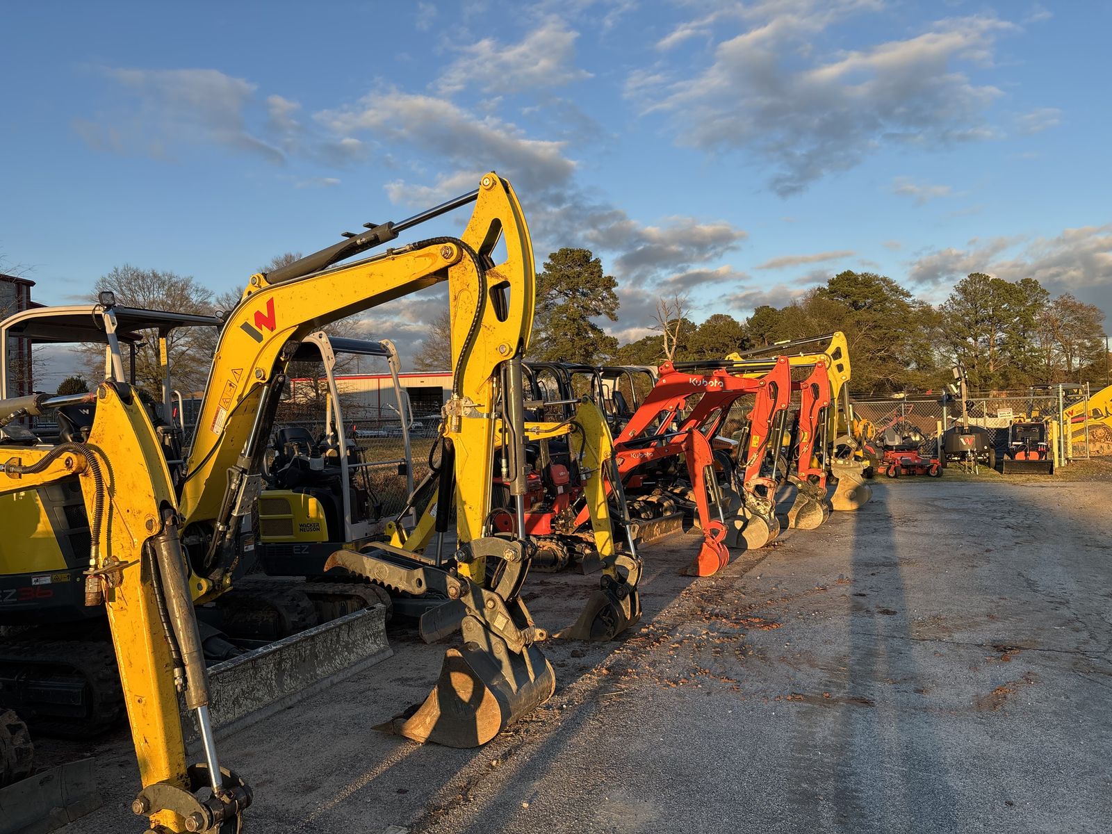 Excavators lined up at the Bulletproof Rentals yard at sunset in Loganville, GA